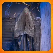 Hængende Halloween-spøgelsesdekoration med flossede grå-sorte lagner, lysende røde øjne og uhyggelige grene bagved.