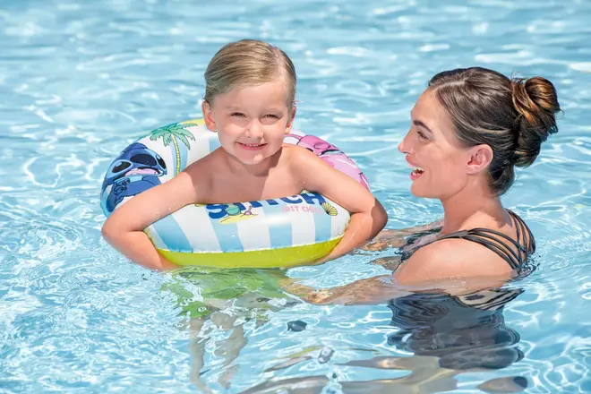 Oppustelig svømmering til børn med farverigt tegneseriedesign, blå og hvide striber og tropiske motiver. Fremstillet af holdbar plast, egnet til pool og giver opdrift til unge svømmere.