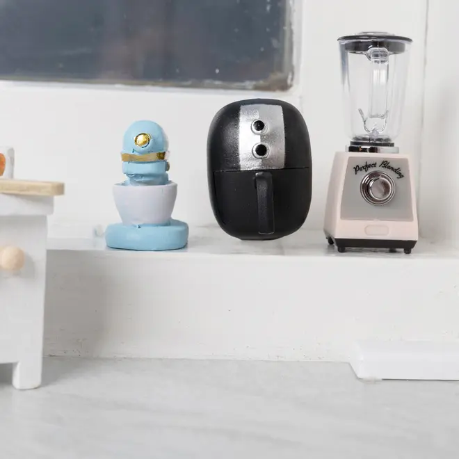 Sæt med tre miniature køkkenapparater: blå røremaskine, sort airfryer og beige blender med klar beholder. Realistiske detaljer, ideel til dukkehus eller udstilling. Malede materialer.
