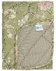 Vatteret tæppe med brun og hvidt blomsterprint på den ene side, beige og hvide striber på bagsiden, blød tekstur og synligt plejemærke. Velegnet til seng eller dekoration.