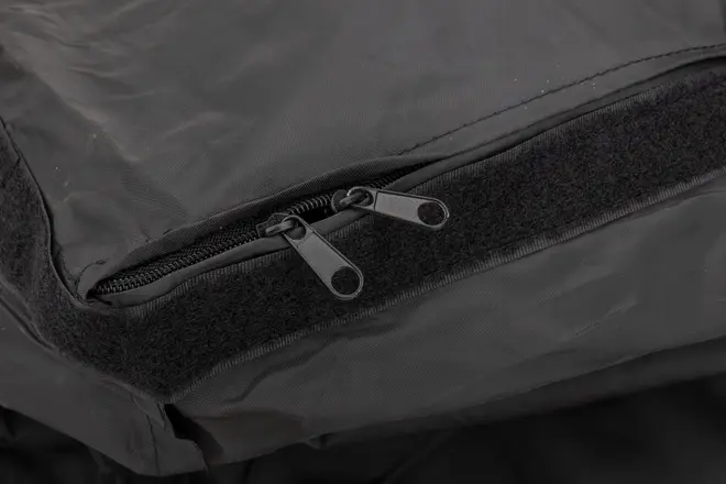 Nærbillede af sort stofpose med to lynlåstræk og en velcrolukning for sikker lukning og nem adgang til indholdet.