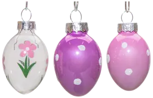 Sæt med tre æggeformede glasornamenter med sølvtoppe: én hvid med lyserød blomst, én lilla med hvide prikker og én lyserød med hvide prikker. Blank overflade.