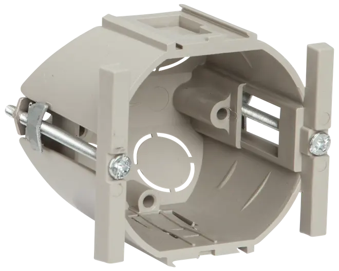 Rund elektrisk vægboks i plast med monteringsskruer og beslag, beregnet til installation af stikkontakter eller afbrydere i gipsvæg. Har udslagsåbninger til ledninger.