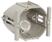 Rund elektrisk vægboks i plast med monteringsskruer og beslag, beregnet til installation af stikkontakter eller afbrydere i gipsvæg. Har udslagsåbninger til ledninger.