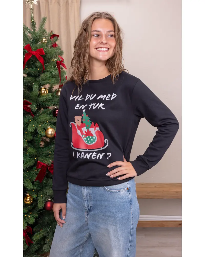 Sort julesweatshirt med dansk tekst, motiv af kane, bamse og juletræ. Lange ærmer, rund hals, afslappet pasform. Bæres med lyseblå jeans.