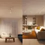 Moderne stue og kontor med hvide justerbare loftsskinne-spotlights, neutrale møbler, rundt sofabord, hyggelige siddepladser og vægge med træpaneler. Perfekt til stilfuld belysning.