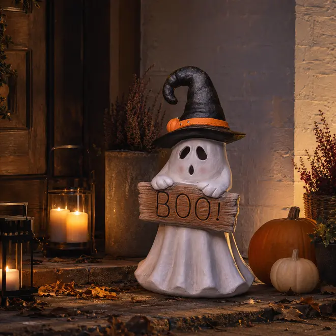 Halloween-spøgelsesfigur med BOO-skilt, sort heksehat med orange bånd og græskarpynt.