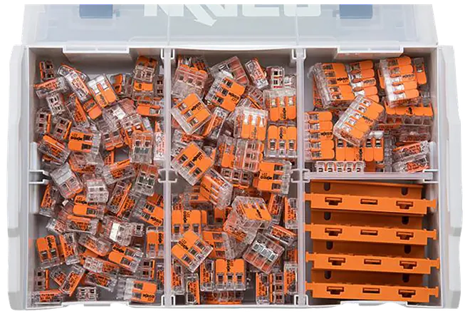 Plastopbevaringsboks med rum fyldt med orange og gennemsigtige elektriske ledningsklemmer samt stablede pakker til højre.