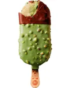 Isbar med grøn pistacieovertræk, sprøde nødder og chokoladelag på toppen. Delvist bidt, så den cremede pistacieis ses indeni. Træpind som håndtag.