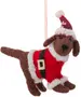 Filtet hundeornament iført rød juleskedragt med hvid kant, sort bælte og nissehue. Ophængssnor medfølger. Blød, håndlavet juledekoration.