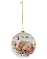 Rund julgranskula i keramik med målad sovande orange katt, omgiven av julgrönt, röda bär och julstjärna, med guldfärgad topp och hängband.