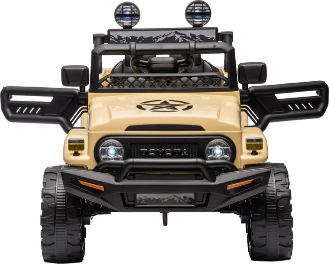 Børne elbil, Toyota model, beige farve, robust offroad-design, fungerende forlygter, åbne døre, store dæk, frontgitter med Toyota-logo, taglygter og detaljeret instrumentbræt.