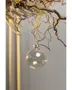 Klar glaskula med silverfäste, hängande i snöre. Enkel och elegant design för julgransdekoration eller festliga arrangemang. Reflekterande yta ger subtil glans.