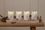 Fyra vita ljus med siffrorna 1 till 4, placerade i en bricka med rosa och silverfärgade kulor, kottar och granris, perfekt för adventsdekoration.