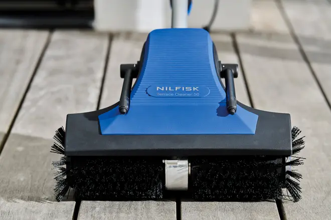 Nilfisk Terrace Cleaner 50 har blå og sort krop, robuste børster og dobbelte håndtag. Ideel til effektiv rengøring af udendørs overflader som terrasser og dæk.