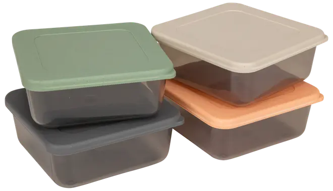 Fyra kvadratiska matlådor i plast med färgade lock (grön, grå, beige, orange). Transparenta bottnar, stapelbara, perfekta för matrester eller matförberedelse.