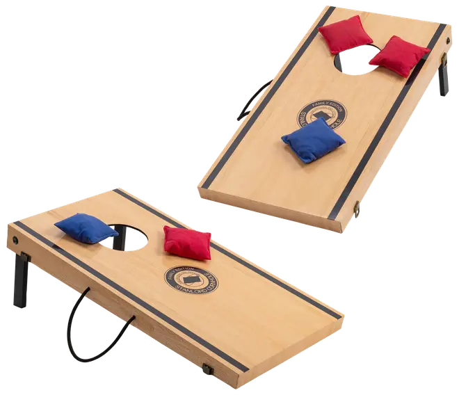 Sæt med to cornhole-brætter i træ med sorte striber og logo, inkluderer røde og blå ærteposer. Brætterne har foldbare ben og bærehåndtag for nem transport.