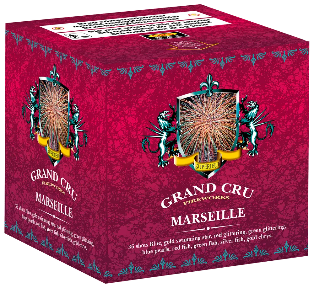 Grand Cru Fireworks Marseille: 36-skuds fyrværkerikage med blå, guld, rød, grøn, sølv og glitrende stjerner. Dekorativ rød æske med våbenskjold og produktinformation.