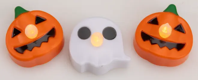 Set med tre LED-värmeljus för Halloween: två orange pumpor med snidade ansikten och ett vitt spöke, alla med glödande låga i mitten.