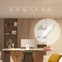 Hvidt loftsskinnebelysningssystem med seks justerbare spotlights, vist i et moderne kontor. Indsat billede fremhæver en hvid forbindelsesdel til samling af skinner.