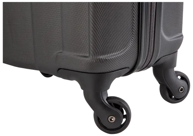 Närbild av hörnet på en hård resväska med texturerad yta, robust plast och två smidiga spinnerhjul för enkel manövrering. Dragkedja syns längs kanten.