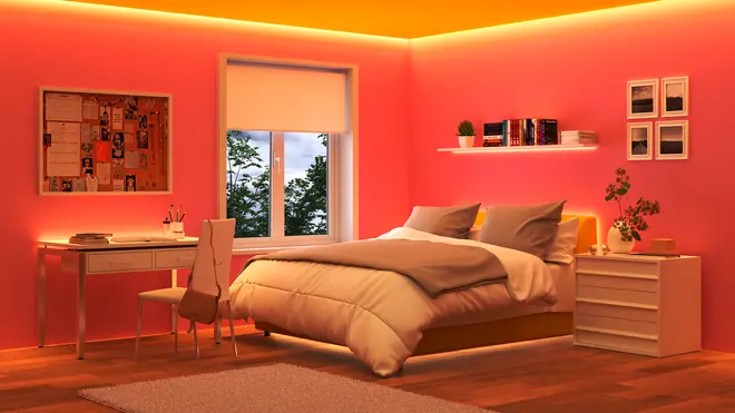 Moderne soveværelse med pink vægge, LED-loftlys, hyggelig seng med beige sengetøj, skrivebord og stol, bogreol, natbord og dekorative planter. Vindue giver naturligt lys.