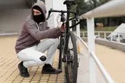 Hvid cykel står på fliser foran rækkehus