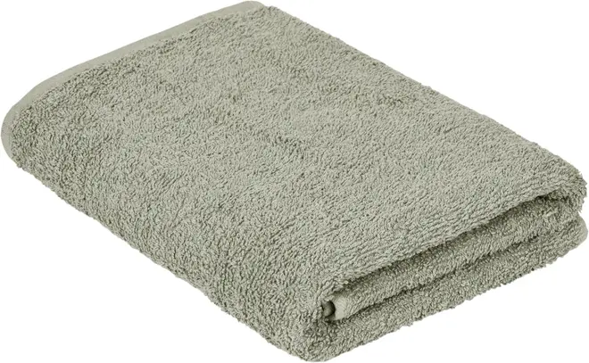 Lysegrønt badehåndklæde, pænt sammenfoldet. Lavet af blødt, absorberende bomuldsterry med diskret kant. Standardstørrelse, ensfarvet design, velegnet til daglig brug og maskinvask.