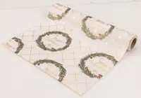 Julbordsduk med guldrutigt mönster, gröna kransar, röda detaljer och texten "Merry Christmas". Tillverkad av tyg, passar för festlig dukning.