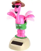 Solcelledrevet pink flamingofigur med grøn nederdel, solbriller og brun hat. Dekorativ plastikfigur, der bevæger sig i sollys, på beige base.