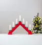 Rød elektrisk lysestage i træ med syv hvide LED-lys, hver pyntet med grønne kranse ved bunden. Perfekt til juledekoration i vindue eller på bord. Tilsluttes strøm.