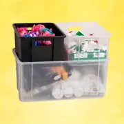 Sæt med tre stabelbare plastopbevaringskasser: én stor gennemsigtig kasse og to mindre åbne kasser i sort og klar plast til legetøj eller tilbehør.