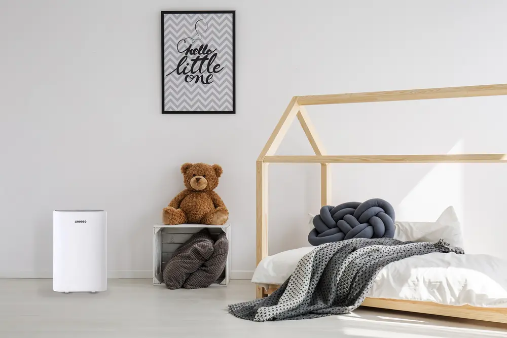 Vit luftrenare med slank, rektangulär design och diskreta kontroller. Kompakt storlek, passar små rum, perfekt för att förbättra luftkvaliteten i barnrum.