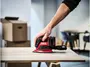 Sladdlös SKIL detaljslip med ergonomiskt grepp, röd och svart design, dammpåse och trekantig slipplatta. Perfekt för precisionsarbete på träytor.