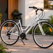 Hvid bycykel med lav indstigning, sort sadel, bagagebærer, skærme, reflekser og opretstående styr. Ideel til pendling og fritidskørsel i byen.