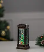 Dekorativ lykta formad som en gammaldags telefonkiosk med julgran, snurrande glitter och LED-belysning. Perfekt som juldekoration eller bordsprydnad.