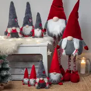 Set med mjuka skandinaviska tomtedockor i olika storlekar, med röda och grå mössor, vita skägg, runda näsor och festliga detaljer för juldekoration.