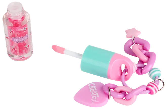 Lyserød kirsebær-lipgloss med turkis og lyserød applikator, fastgjort til en kraftig lyserød kæde med dekorative charms, herunder et hjerte med teksten 'CREATE!' og en stjerne.
