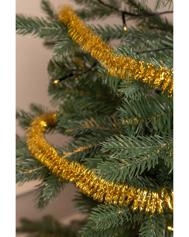 Guldfärgad glittrande girlang lindad runt en grön konstgjord julgransgren, med glänsande metalltrådar. Perfekt för julgransdekoration och festlig inredning.