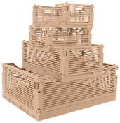 Stabel af fire beige plastikkasser med slidsede sider og håndtag. Forskellige størrelser, sammenklappelige og stabelbare, perfekte til opbevaring og transport af ting.