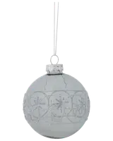 Klar glaskula med silverglittrigt snöflingemönster, rund form, silverfäste och upphängningsögla. Elegant och festlig dekoration för julgran eller säsongsutsmyckning.