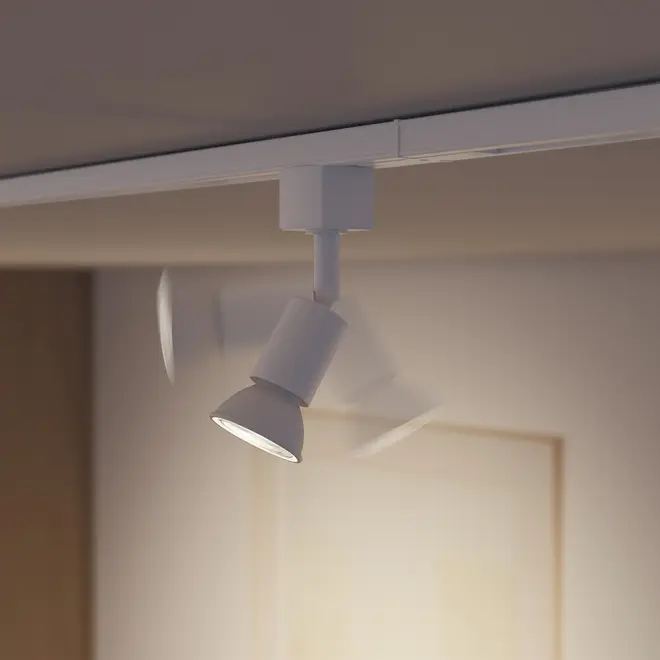 Hvid justerbar spotlampe monteret på loftsskinne, med cylindrisk lampehoved der kan drejes og vippes for fleksibel belysning. Moderne og minimalistisk design.