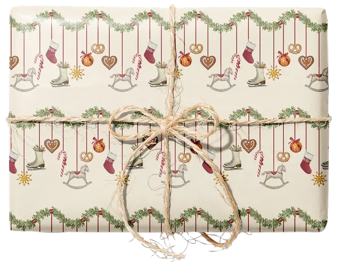 Inslagen present med krämfärgat julpapper dekorerat med girlanger, strumpor, polkagriskäppar, hjärtformade kakor, skridskor och gunghästar, knuten med rustik snörrosett.