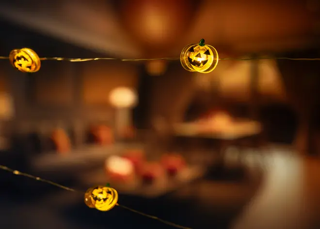 Ljusslinga med små, upplysta pumpaformade höljen med utskurna ansikten, perfekt för Halloween-dekoration. Pumporna ger ett varmt gult sken för inomhusmiljö.