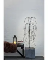 Konstgjord hängpil med LED-lampor, smala svarta grenar och fyrkantig grå kruka. Passar som modern inomhusdekoration med stämningsfull belysning.