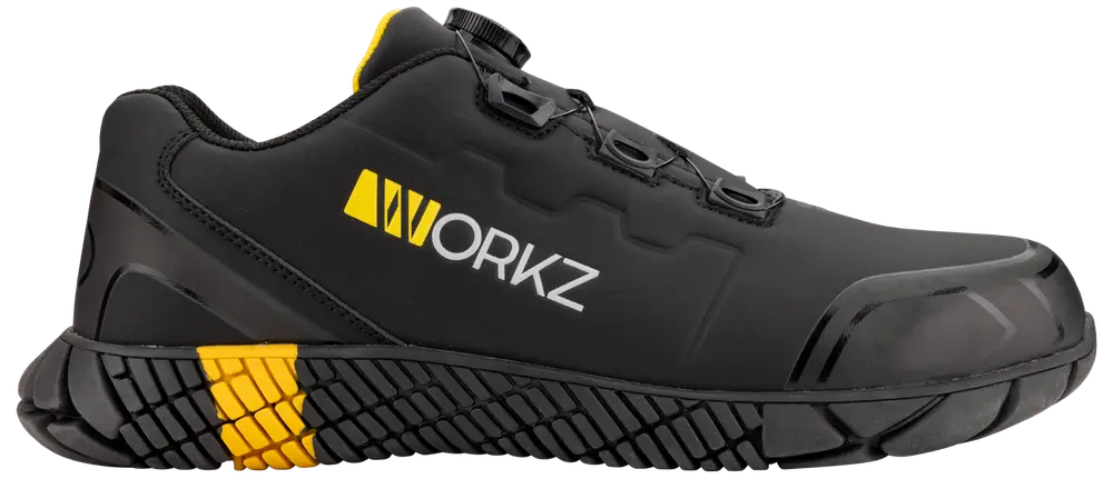 Svart arbetssko med förstärkt tå, halksäker sula, gula detaljer och WORKZ-logga. Slitstarkt syntetmaterial, snörning, designad för säkerhet och komfort på arbetsplatsen.