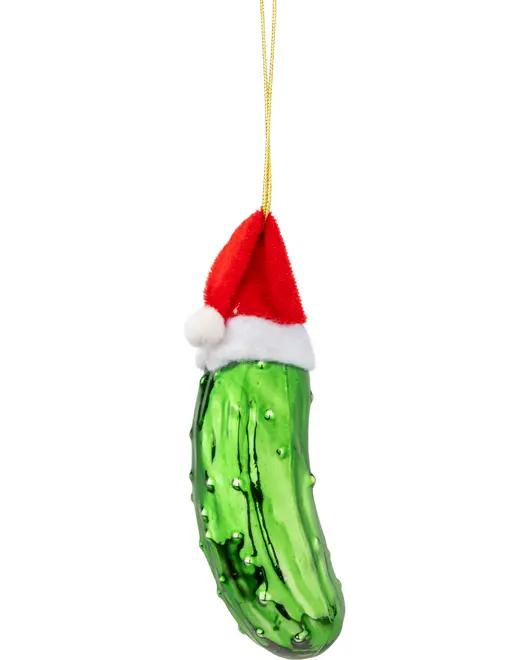 Grønt glasagurk juleornament med knopper, iført rød og hvid nissehue, hængende i en guldsnor. Sjov og festlig juledekoration.
