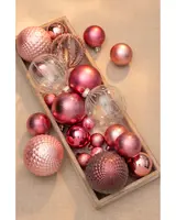 Set med blandade rosa och klara julgranskulor i olika storlekar och ytor, inklusive matta, blanka och fasetterade, perfekta för julgransdekoration eller festliga arrangemang.