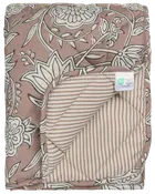 Vatteret tæppe med brun og hvidt blomsterprint på den ene side, beige og hvide striber på bagsiden, blød tekstur og synligt plejemærke. Velegnet til seng eller dekoration.