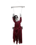 Halloween-dekoration med docka i lång röd klänning med vit spetskrage och manschetter, sittande på en gunga med uppsträckta armar, avsedd för upphängning.
